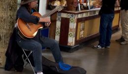 man playing guitar in mall