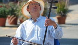 man playing Chinese instrument