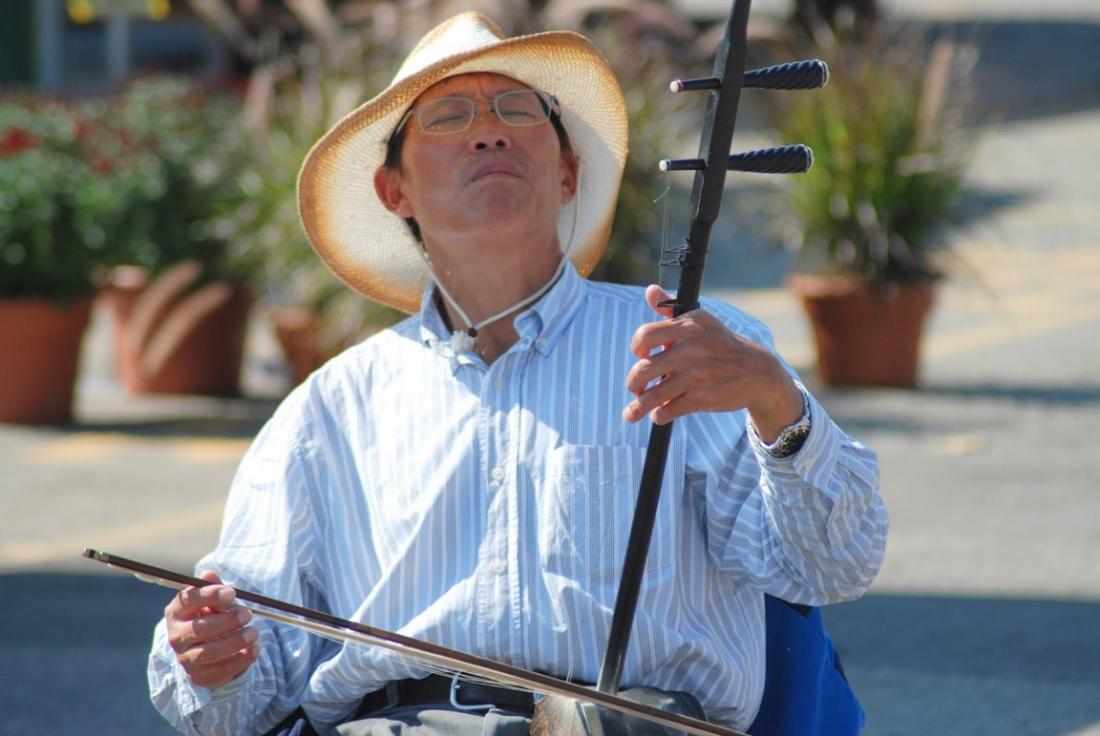 man playing Chinese instrument